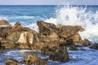 Dalgalar ve Kıbrıs Adası Deniz kıyısında taş döşeme üzerinde kırma sprey.
