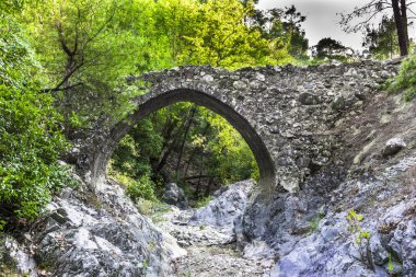 Batan güneşin son ışınları antik taş kemer Troodos dağ orta kısmında Venedik köprü aydınlatılmış.