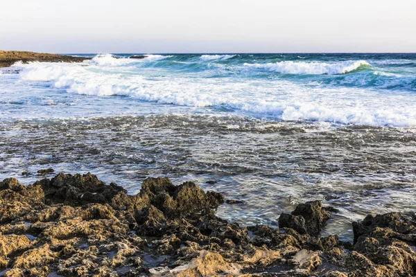 在塞浦路斯岛上夕阳的最后一缕波浪上 暴风雨般的海浪在岩石的岸边折断 — 图库照片