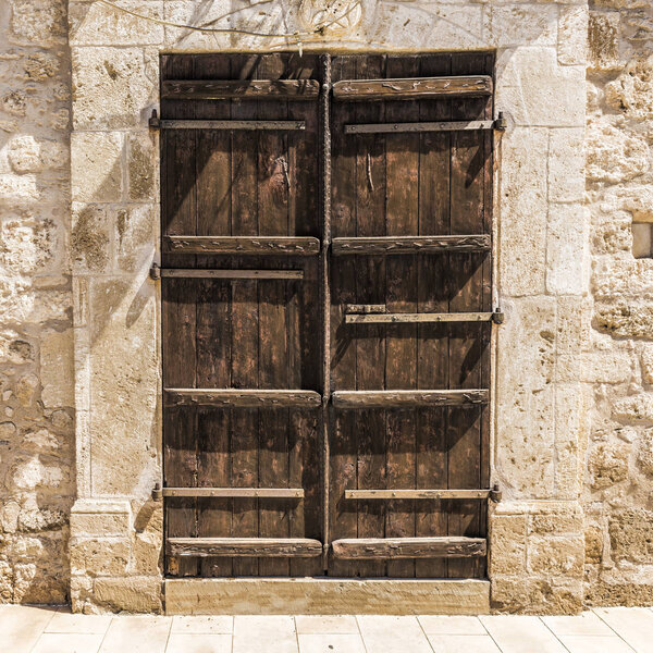 Very old wooden door in a stone Greek house in the centre of the island of Cyprus.