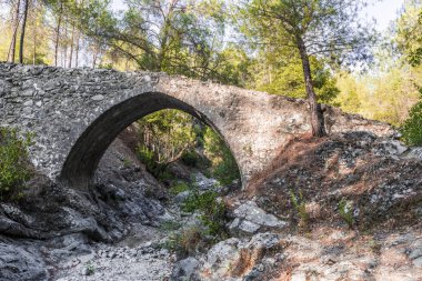 Batan güneşin son ışınları antik taş kemer Troodos dağ orta kısmında Venedik köprü aydınlatılmış.