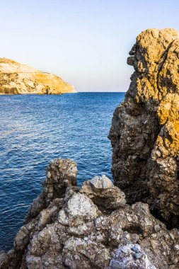 Batan güneşin son ışınları Aphrodite Bay Kıbrıs sahil çevresinde kırmızı dağlar boyalı.