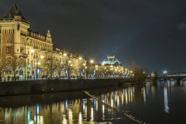 Gece ışıkları eski Prag Vltava Nehri sessiz, karanlık sularda yansıtılır.
