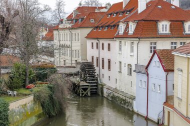 Eski Prag'da Vltava Nehri'nin ve sakin kanallardan biri içinde eski bir ahşap watermill tekerlek.