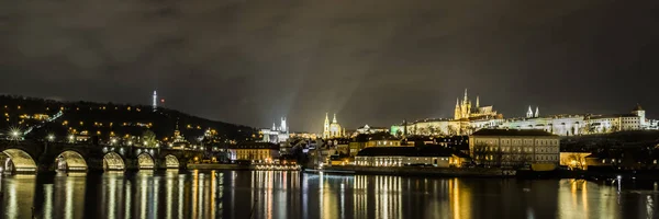 Gece ışıkları eski Prag Vltava Nehri sessiz, karanlık sularda yansıtılır.