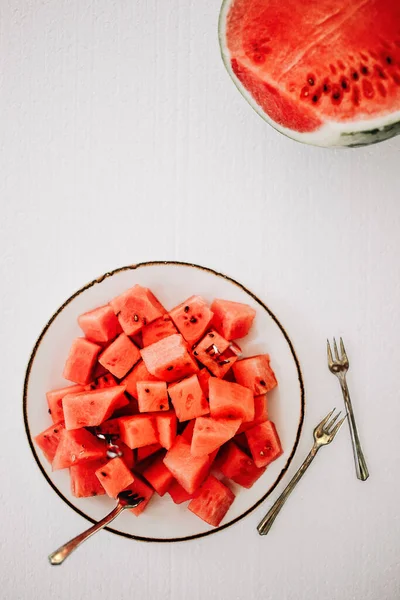 Water melon cut in small pieces on white background.