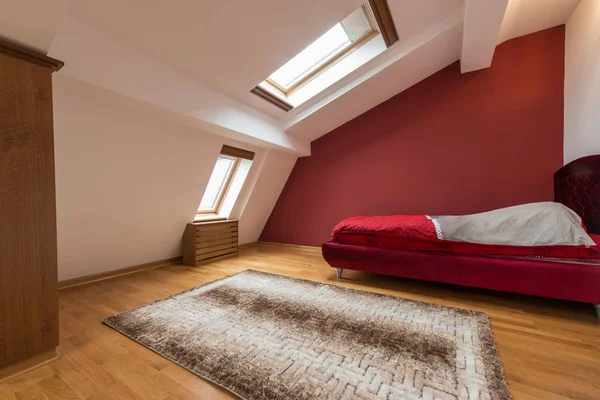 Interior do quarto em loft vermelho de luxo, sótão, apartamento com telhado — Fotografia de Stock