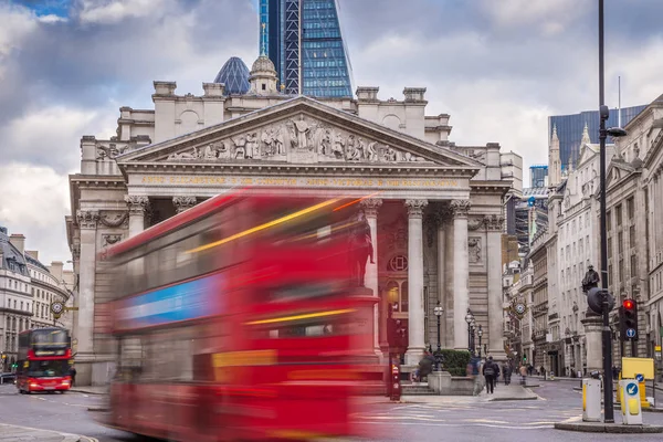 London, Anglia - ikonikus piros emeletes buszok a mozgás és a Royal Exchange-building — Stock Fotó