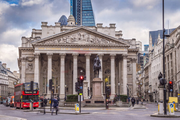 London, England - Iconic red double decker bus and the Royal Exchange building