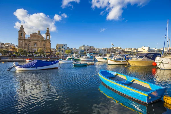 Msida, Malta - tradicional barco de pesca maltés pintado de azul con la iglesia parroquial de Msida en el fondo en un día de verano cielo azul — Foto de Stock