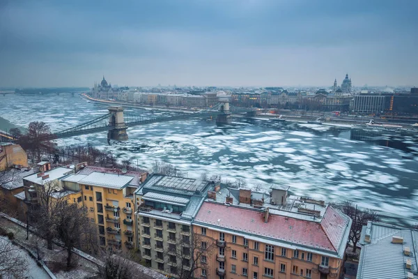 Budapest, Hungary - Panoramic skyline view of the Szechenyi Chain Bridge on the icy River Danube with Parliament and Bazilika at background on a winter morning — Stock Photo, Image