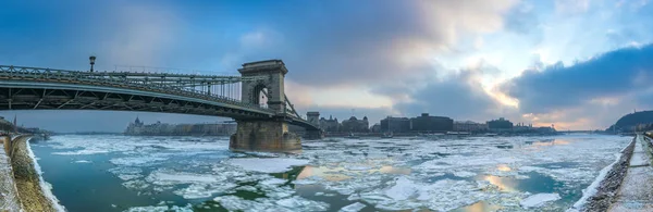 Budapest, ungarisch - die berühmte szechenyi-Kettenbrücke über die eisige Donau mit Parlament und Gellert-Hügel im Hintergrund an einem kalten Wintermorgen — Stockfoto
