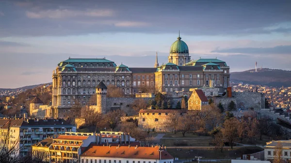 Budapeste, Hungria - O famoso Castelo de Buda (Palácio Real), a Igreja de St. Matthias e o Bastião dos Pescadores ao pôr-do-sol numa agradável tarde de inverno tirada de Gellert Hill — Fotografia de Stock