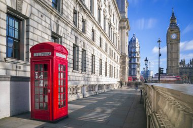 Londra, İngiltere - geleneksel kırmızı İngiliz telefon kutusu arka plan mavi gökyüzü ve bulutlar ile güneşli bir öğleden sonra Big Ben ve Çift katlı otobüs ile