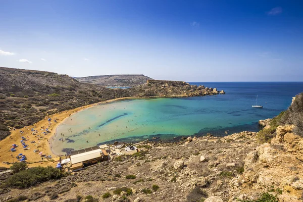 Ghajn Tuffieha, Málta - szép nyári nap-Ghajn Tuffieha homokos strandon a kék ég és zöld kristálytiszta tengervíz — Stock Fotó