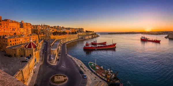 Valletta, Malta - panoramische opname van een geweldige zomer zonsopgang op de Valletta Grand Haven met schepen en de oude huizen en de muren van de maltese hoofdstad. — Stockfoto