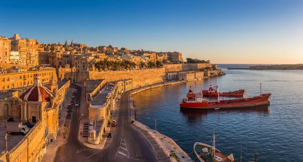 Valletta, Málta - Skyline view Valletta és a Grand-kikötőre gyönyörű napfelkelte, a hajók és a tiszta kék ég — Stock Fotó