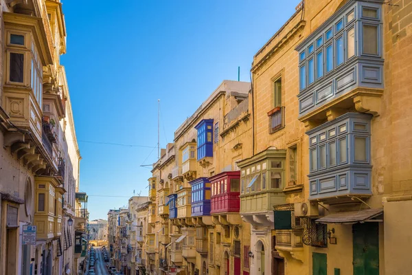 Valletta, Malta - renkli geleneksel windows ve Balkonlu ve açık mavi gökyüzü bir yaz gününde tipik dar sokak