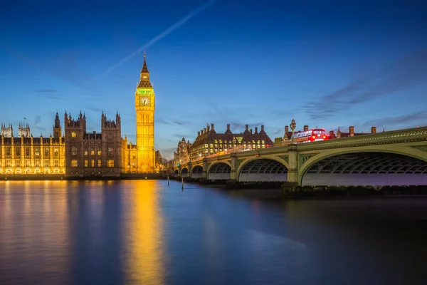 Λονδίνο, Αγγλία - ο πύργος ρολογιού Big Ben και τα κτίρια του Κοινοβουλίου με εικονική κόκκινο διώροφα λεωφορεία στην πόλη του Γουέστμινστερ από νύχτα — Φωτογραφία Αρχείου