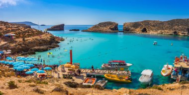 Comino'daki, Malta - açık mavi gökyüzü ve Comino Island, Malta gemilerde bir güneşli yaz gününde açık turkuaz su zevk için Blue Lagoon turist kalabalığa.