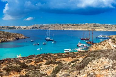 Comino'daki, Malta - Adası Comino Yelkenliler, geleneksel Luzzu tekneleri ve masmavi Akdeniz su ve güneş zevk turist ile ünlü ve güzel Blue Lagoon görünümünü panoramik manzarası
