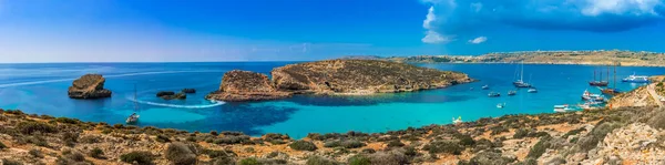 Comino, Malta - Vista panorâmica da famosa e bela Lagoa Azul na ilha de Comino com veleiros, barcos tradicionais Luzzu e turistas desfrutando da água do mar mediterrâneo azul e sol — Fotografia de Stock