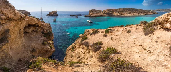 Comino, Malta - La hermosa Laguna Azul con agua de mar turquesa clara, yates y turistas de snorkel en un día soleado de verano con la isla de Gozo en el fondo — Foto de Stock