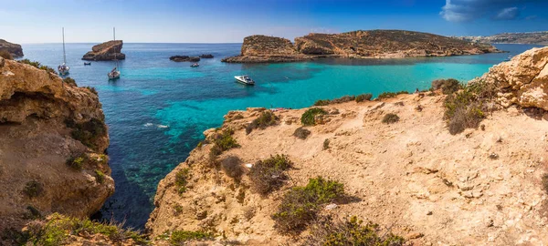 Comino, Malta - de prachtige Blue Lagoon met turquoise zeewater, jachten en snorkelen toeristen duidelijk op een zonnige zomerdag met op de achtergrond het eiland Gozo — Stockfoto