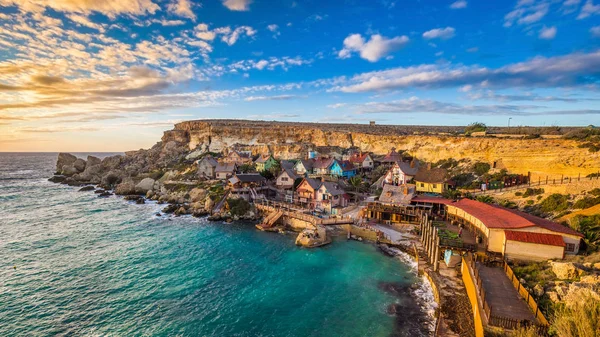 Il-Mellieha, Malta - Puesta de sol en el famoso Popeye Village en Anchor Bay. Este pueblo fue el escenario de la famosa película de Robert Altman 'Popeye' con Robin Williams en el papel principal . — Foto de Stock