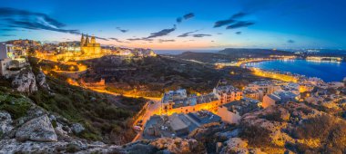 Il-Mellieha, Malta-güzel panoramik manzarası görünümü ile arka plan mavi gökyüzü ve bulutlar ile Paris kilise ve Mellieha kumsalda güneş battıktan sonra Mellieha şehrin