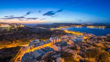 Il-Mellieha, Malta-Mellieha bay mavi gökyüzü ve bulutlar güneş battıktan sonra görünümünü güzel panoramik manzarası
