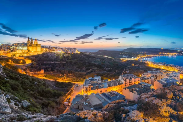 Il-Mellieha, Malta-piękne panoramiczne panoramę miasta Mellieha po zachodzie słońca z plaży Paris Kościół i Mellieha w tle z blue sky i chmury — Zdjęcie stockowe