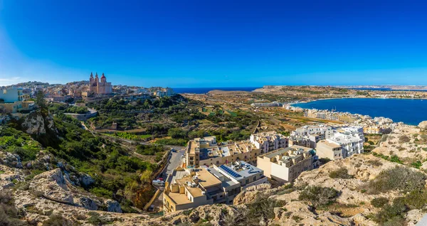 Il-Mellieha, Malta - Hermosa vista panorámica de la ciudad de Mellieha en un brillante día de verano con la Iglesia de París, la Torre Roja de Agatha y la playa de Mellieha al fondo con cielo azul y nubes — Foto de Stock