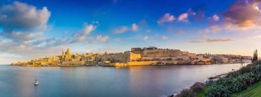 Valletta, Malta - Valletta Antik şehir ve Sliema panoramik manzarası görünümünü gündoğumu, bahar zaman yelkenli tekne, mavi gökyüzü, güzel bulutlar ve yeşil çim Manoel adadan ateş