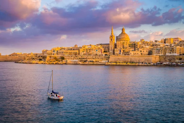 Valletta, Malta - St.Paul 's Cathedral v zlaté hodiny na maltské hlavní město Valletta s plachetnice a krásné barevné nebe a mraky — Stock fotografie
