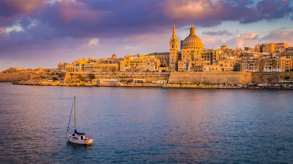 La Valeta, Malta - Catedral de San Pablo en hora dorada en la capital de Malta La Valeta con velero y hermoso cielo colorido y nubes — Foto de Stock