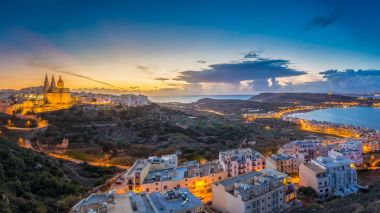 Il-Mellieha, Malta-güzel panoramik manzarası görünümü Gozo, mavi gökyüzü ve bulutlar arka plan ve mavi saatte Paris kilise ve Mellieha plaj ile Mellieha şehir