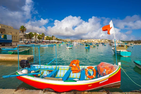 Marsaxlokk, Malta - Pescador tradicional y colorido de Luzzu en el antiguo mercado de Marsaxlokk con agua de mar turquesa y palmeras en un día de verano — Foto de Stock