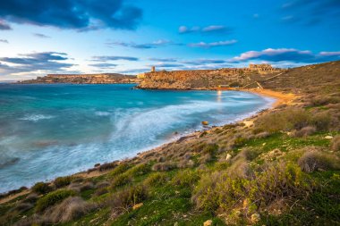 Mgarr, Malta - ünlü Ghajn Tuffieha bay uzun pozlama mavi bir saatte güzel gökyüzü ve bulutlar ile vurdu