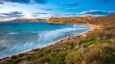 Mgarr, Malta - The famous Ghajn Tuffieha bay at blue hour on a long exposure shot with beautiful sky and clouds clipart