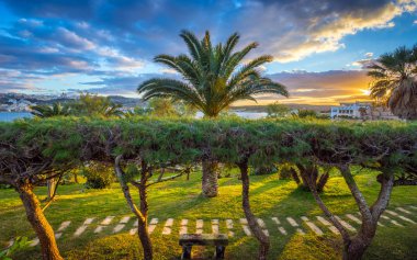 Il-Mellieha, Malta-güzel günbatımı olay yerinde palmiye ağaçları, tezgah ve renkli gökyüzü Mellieha beldesi