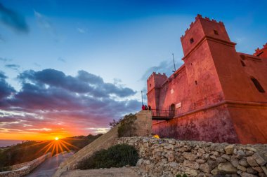 Il-Mellieha, Malta - Tourists watching sunset at St Agatha's Red Tower with beautiful sky and clouds  clipart