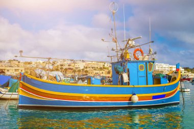 MARSAXLOKK, Malta - geleneksel renkli Malta Luzzu fisherboat eski Marsaxlokk köyü ile turkuaz deniz suyu bir parlak yaz gününde