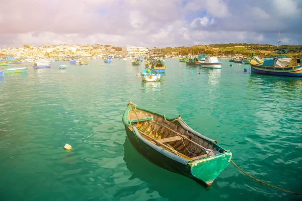 Marsaxlokk, Malta - traditionella gröna maltesiska Yuna fisherboat på den gamla marknaden av Marsaxlokk med gröna havet vatten, blå himmel och palmer på en sommardag — Stockfoto