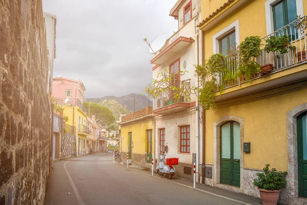 Taormina, Sicilia - Típica calle romántica italiana de Taormina, la encantadora ciudad de la cima de la colina en la isla de Sicilia con estacionamiento scooter y colinas en el fondo — Foto de Stock