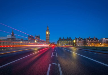 Londra, İngiltere - Big Ben'e ve Parlamento ortasından Westminster Bridge, arabalar ve tarafından geçen otobüsler ışıkları ile alacakaranlıkta çekilen