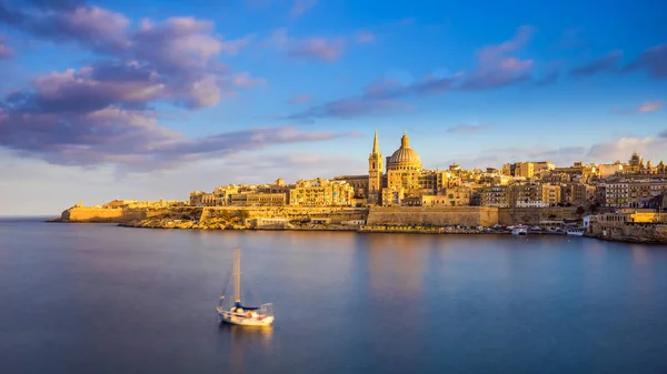 La Valeta, Malta - Catedral de San Pablo en hora dorada en la capital de Malta La Valeta con velero y hermoso cielo colorido y nubes — Foto de Stock