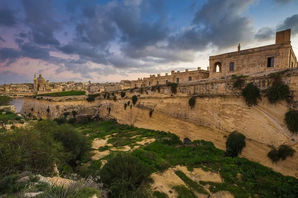 Isla de Manoel, Malta Fortaleza de piedra caliza abandonada en el centro de la isla de Manoel con la Catedral de San Pablo y La Valeta al fondo — Foto de Stock