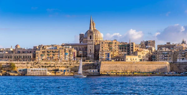 Valletta, Malta - panoramiczny widok na katedrę Saint Paul i mury Valletty z żaglem łodzią w godzinach porannych — Zdjęcie stockowe