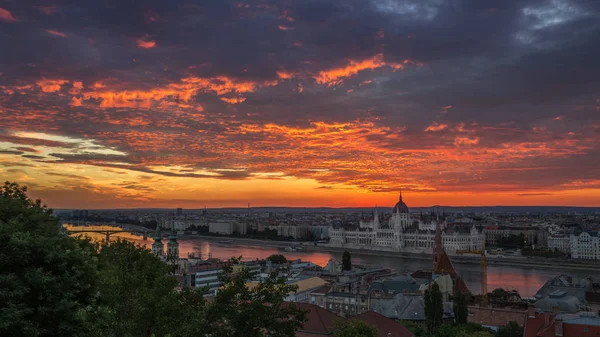 Budapest, Magyarország - drámai színes felhők és a napkelte felett Budapest és a magyar Parlament — Stock Fotó